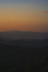 nature traveling with orange sky and layer of mountain with sunrise background