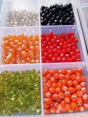 Colorful vibrant crystal beads organized in plastic compartment box