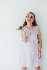 woman in summer dress holding out showing green candle
