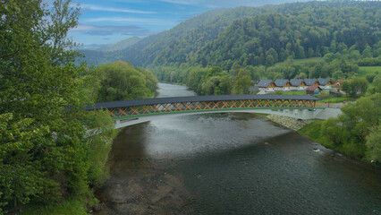 Fototapeta premium The pedestrian and bicycle bridge known as the “Broken Bridge” spanning the Dunajec River in the picturesque Pieniny Mountains, close to the town of Kroscienko, Poland.