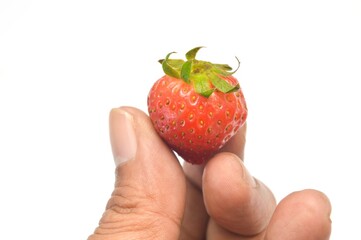 Close up view of strawberry harvest held in hand on white background. Concept of healthy food,...
