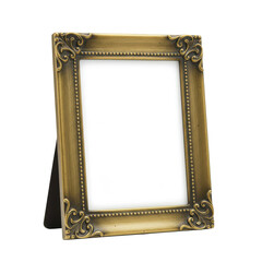 Ornate, empty gold frame with delicate scroll details, standing on a black easel, against black backdrop