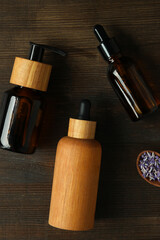 Lavender oil in bottles with lavender flowers on a dark background
