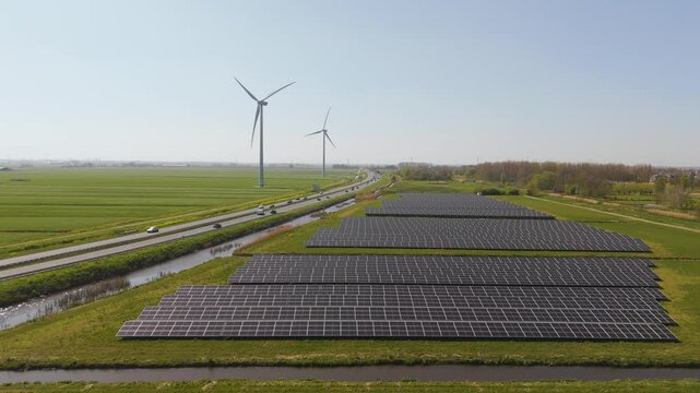 Cinematic drone footage of large-scale solar panel rows in the Dutch countryside, near Delft. Represents clean energy, green technology and sustainable landscape integration.