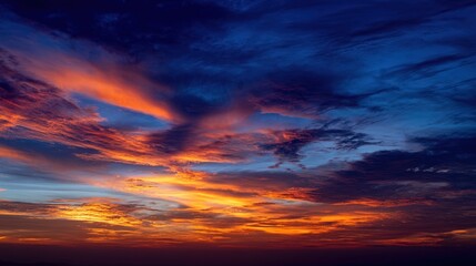 Obraz premium Fiery Dramatic Sky at Sunset with Orange and Blue Clouds creating a stunning backdrop and atmospheric mood for landscape
