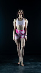Fototapeta premium Young beautiful woman with athletic body on dark background. Fitness girl 