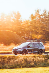 Fototapeta premium Black car on sunny rural road