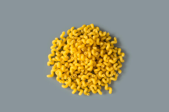 Top  view of a raw italian durum wheat cavatappi pasta against a gray background , high-resolution  . Isolated raw dry succhietti pasta , place for text .