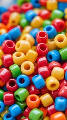 Close-up of colorful plastic pony beads in vivid red, yellow, green, blue, and orange tones, ideal for crafting, DIY jewelry projects, or playful creative design concepts

