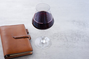 A glass of wine with Notebook on Table

