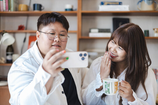Diverse couple of gender expressions enjoy cozy lifestyle together while sharing joyful moment in warm lgbtq friendly home environment