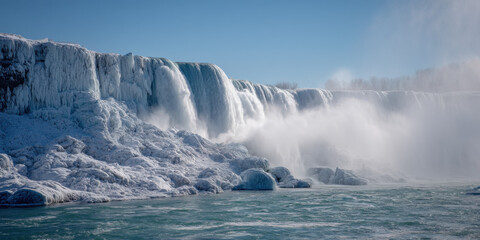 Frozen Niagara Falls in winter, showcasing massive ice formations on the cliff face and powerful water cascading down, a breathtaking winter landscape. : Generative AI
