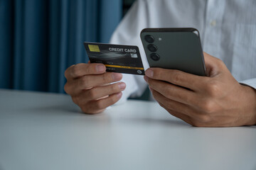 Man holding credit card and phone to pay online