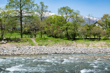 残雪の北アルプスと清流　長野県白馬村