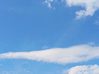 Puffy White Cumulus Cloud on a Clear Blue Sky. Bright Summer Day Cloudscape Background. Serene Sky...