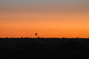 Sonnenuntergang in der Kalahari mit Blick auf ein Windrad