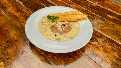 A delicious bowl of creamy soup with a vibrant herb garnish, elegantly paired with a crunchy breadstick for a delightful dining experience.