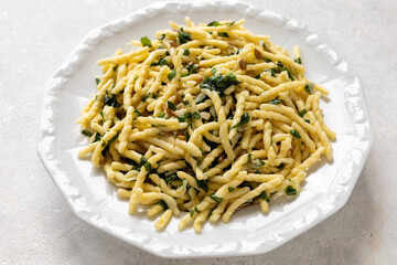 Trofie pasta with roughly chopped basil pesto on a plate. Trofie al Pesto - famous Ligurian dish. 