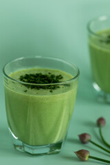 Close-up view of a glass of blended buttermilk with chives. Chive buds on the side.