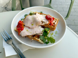 Potato Waffles with Turkey Pastrami, Roasted Sweet Pepper, Cream Cheese, and Cilantro on Outdoor Table. Healthy Breakfast Out Concept. Handmade Mobile Photo, Selective Focus, Not AI