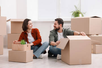 Moving day. Happy couple unpacking their belongings in new home