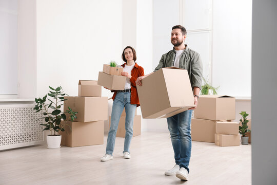 Moving day. Happy couple with their belongings in new home