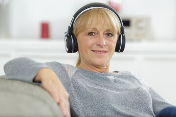 happy mature woman using headphones at home