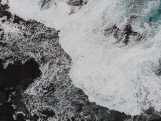 Aerial View of Waves Crashing on Rocky Shore