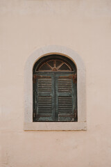 Classic Green Shutter on a Rustic Beige Wall, Evoking Mediterranean Charm