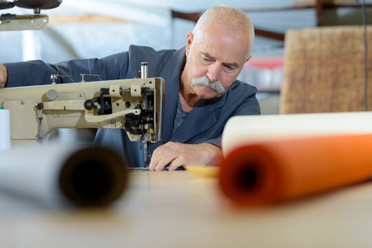 a senior upholsterer sewing cover
