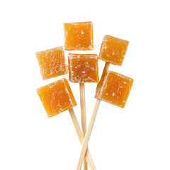 Orange-flavored square candies on sticks