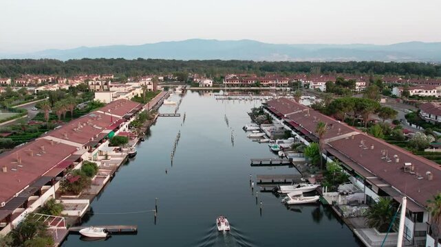 A drone over a small town on a lake. Marinas, Cloudy summer sunset. Sibari, Italy.