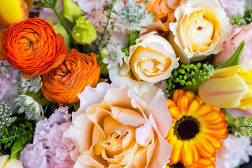 Soft tone floral arrangement with orange peonies and roses