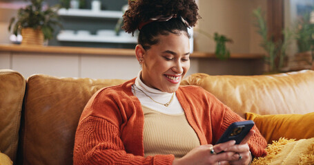Girl, smile and typing with phone on sofa for dating site, mobile chat or reading online news. Gen...