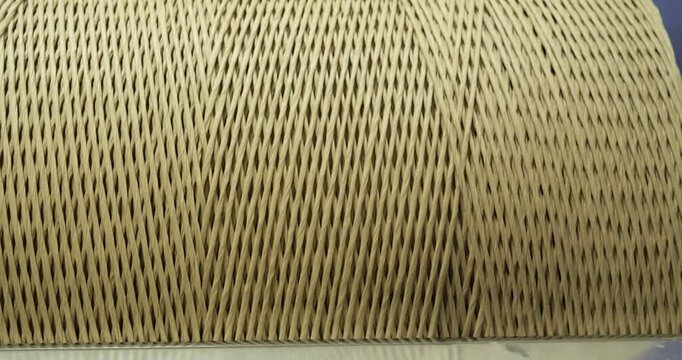 Close-up of tightly wound industrial paper cord spool, texture of twisted kraft paper strands
