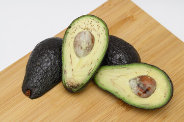 Świeże owoce awokado przekrojone na pół, widoczna duża pestka  © Paweł Kacperek