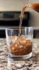 Refreshing Beverage Poured Over Ice in Clear Glass on Countertop