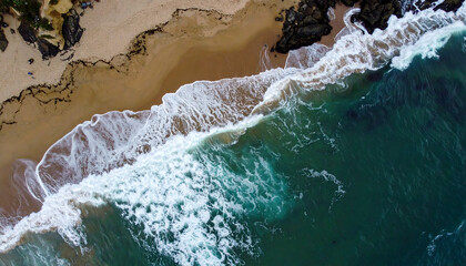 Fototapeta premium Breathtaking aerial view of crashing ocean waves along sandy shoreline capturing natural beauty
