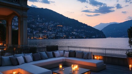Sunset over lake from elegant hotel terrace with candlelit seating and soft lights