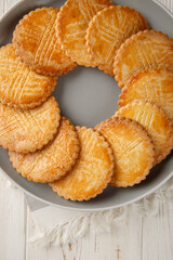 Sable Breton is a classic French butter cookie traditionally made with a shortbread type of dough and salted butter closeup on the plate on the table. Vertical top view from above