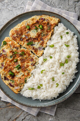 Motta Porrichu Spicy Coconut Ginger Omelette with rice closeup on the plate on the table. Vertical top view from above