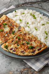 Motta Porrichu Spicy Coconut Ginger Omelette with rice closeup on the plate on the table. Vertical