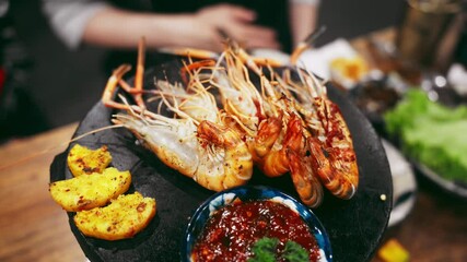 Relish sizzling grilled shrimp on a hot stone plate in this stock video. Close-up reveals vibrant colors and tantalizing textures of gourmet seafood