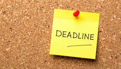 Deadline reminder on yellow sticky note pinned to corkboard in office environment for productivity focus