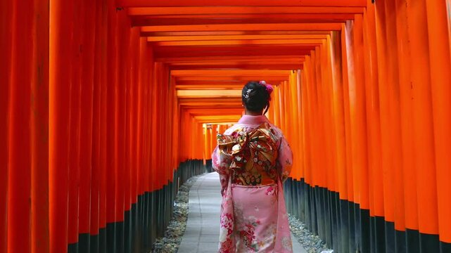 Asian women in traditional japanese kimonos visiting at Fushimi Inari Shrine in Kyoto, Japan.	