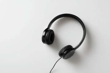 minimalist display of headphones on white background softly illuminated with warm light creating gentle shadows