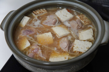 鶏肉と焼き豆腐の鍋を作る様子