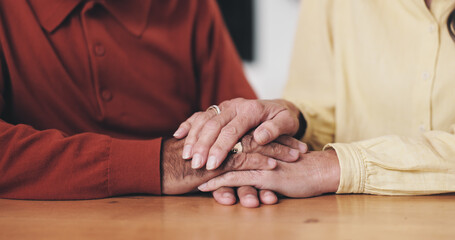 Home, table and old couple with holding hands for support, empathy and comfort to partner with grief. Closeup, senior people and love with sympathy for loss, compassion and kindness with commitment