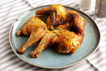 Homemade Grilled Chicken Tabaka on a Plate, side view.