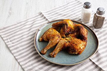 Homemade Grilled Chicken Tabaka on a Plate, side view. Copy space.